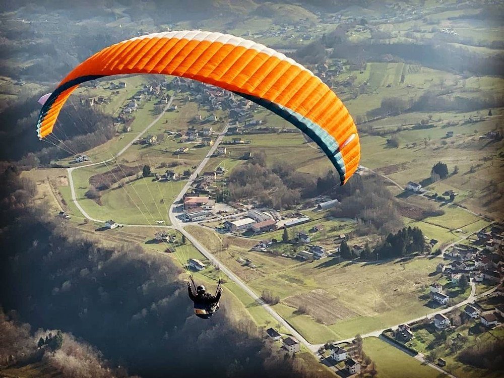 Parapendio in volo sopra l'Alpago